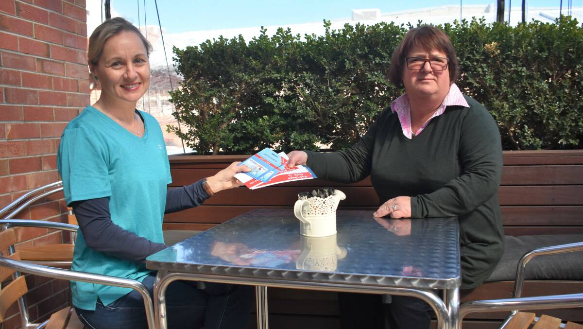 GIVIT NSW drought support officer Melissa Bowman hands over vouchers to Inverell Sunrise CWA member Jane Hunter on Wednesday at Out The Back Cafe.