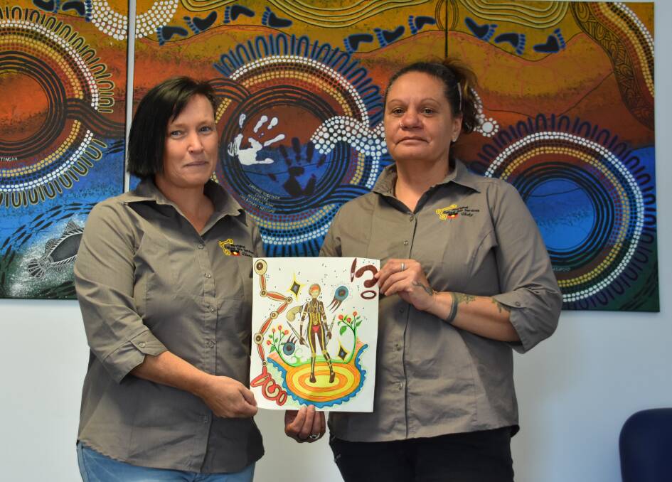Diane Marlow and Aboriginal artist Vicky Duncan with her original design concept for the 2018 Inverell NAIDOC Week shirts.