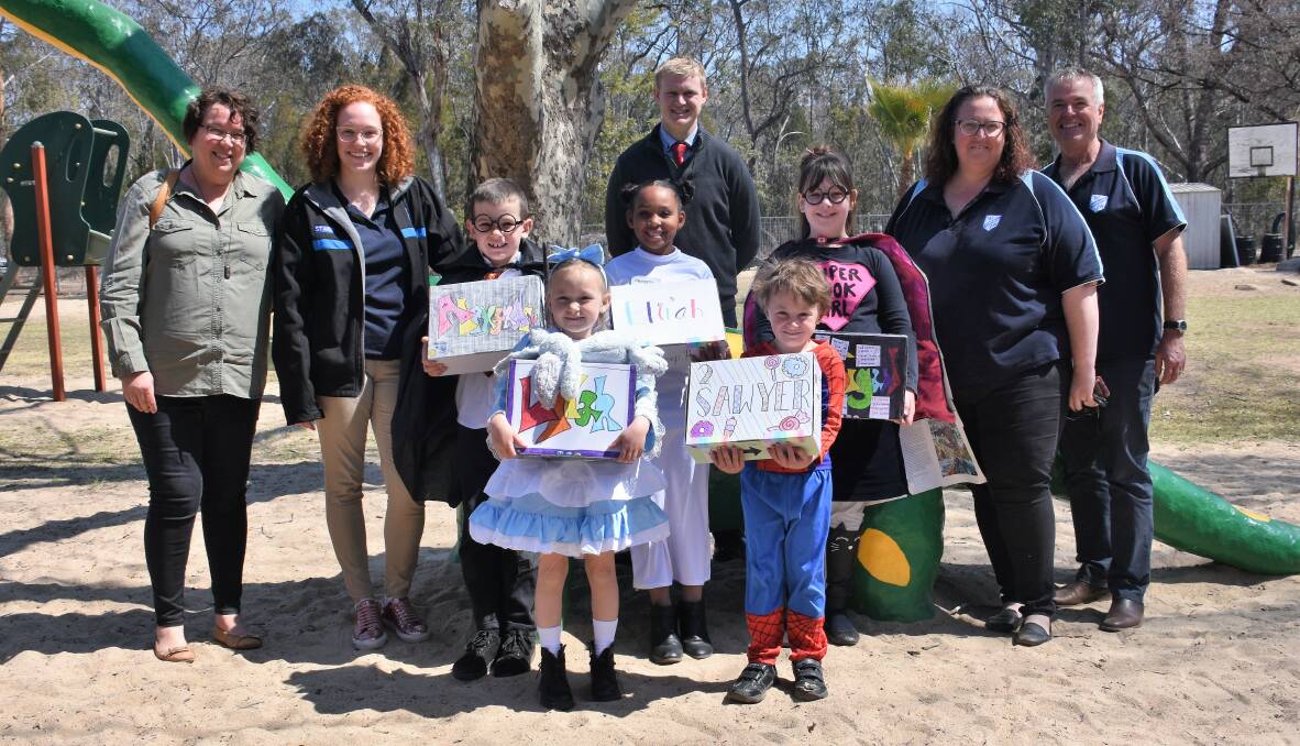 Happy packs: Gilgai Public School students proudly hold their personalised boxes with Westmead Public School staff on Thursday.