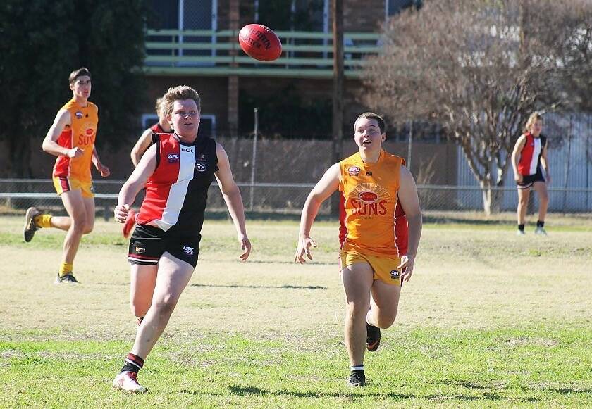 Race to the ball: Saints player Tim Beattie (left) runs to catch the ball against the Moree Suns on Saturday. After recently switching footy codes, Beattie is starting to shine on field.