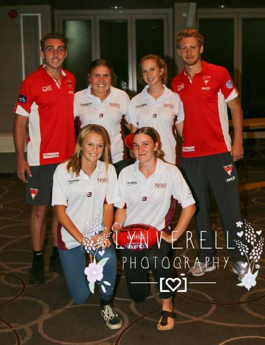 NIAS AFL athletes: Kayla Sim, Kelsie Julius, Sophie Kastelein and Kyla Hamilton pictured with Sydney Swans players Callum Mills and Dan Robinson, prepare to play at Newcastle this weekend. Photo: Lynverell Photography.
