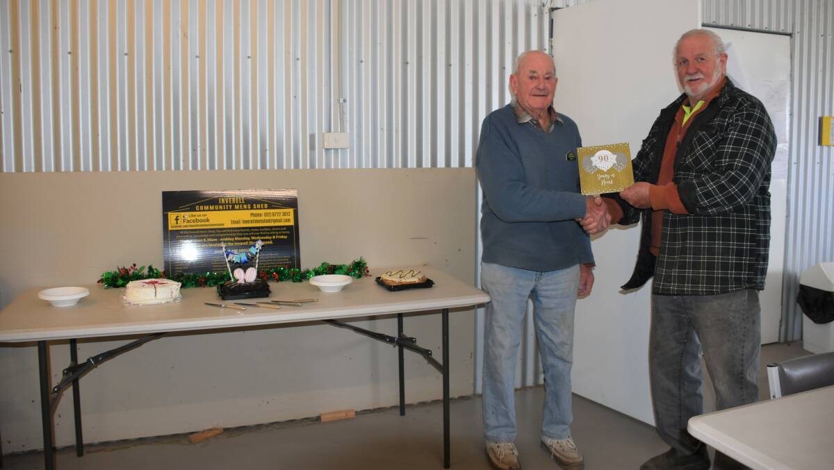 Celebration: Inverell Men's Shed member Noel Barry accepts a 90th birthday card off president and good friend Greg Brabant during a small gathering on Friday.