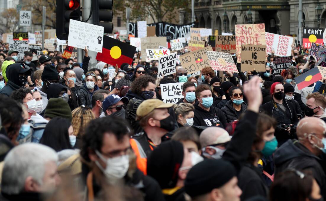 Protesters holding up signs in Bourke Street, Melbourne last month. The protests made many people feel that social distancing didn't matter as much anymore. Photo: Speed Media/Getty Images
