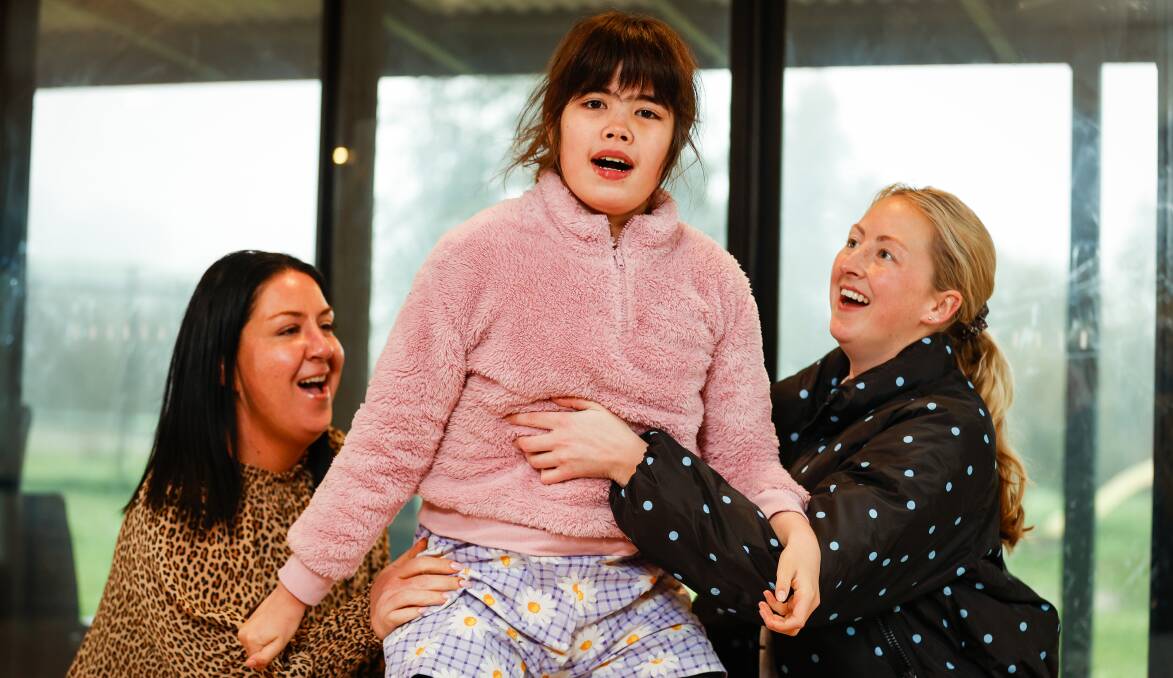 SMILES: Skye Robson (centre) with carers Bree Pellow (left) and Teghan Henderson. Picture: Luke Hemer