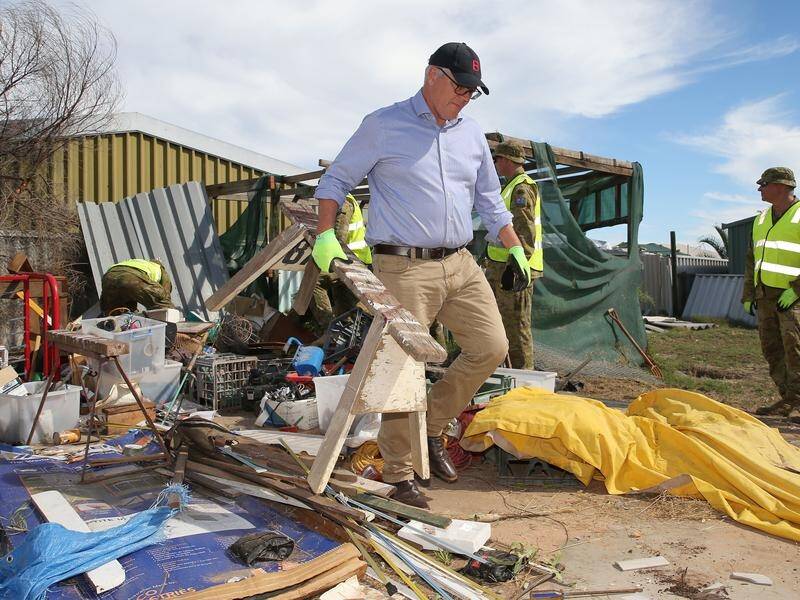 Scott Morrison helped ADF members clear collapsed fence panels from a cyclone-damaged property.