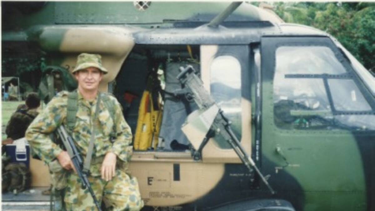 A younger, serving Pat McMahon beside a Blackhawk in East Timor.
