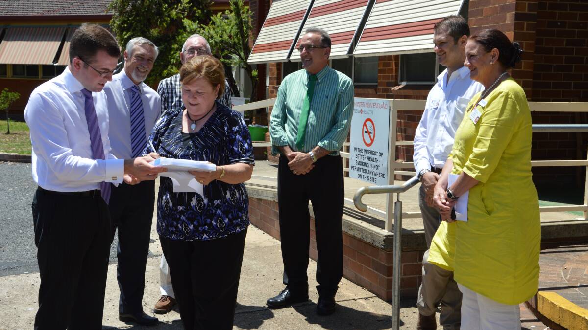 Member for Northern Tablelands Adam Marshall, left, watches Operation Operating Room President Di Baker sign one of the first letters to the Minister for Health Jillian Skinner, calling for the government to commit funding to redevelop the Inverell District Hospital.