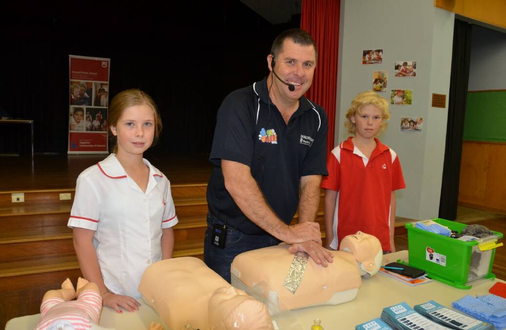 FUNDAMENTALS: Cameron McFarlane (centre) demonstrates CPR to Inverell Public School students Takiah Paton and Keyton Rynne.