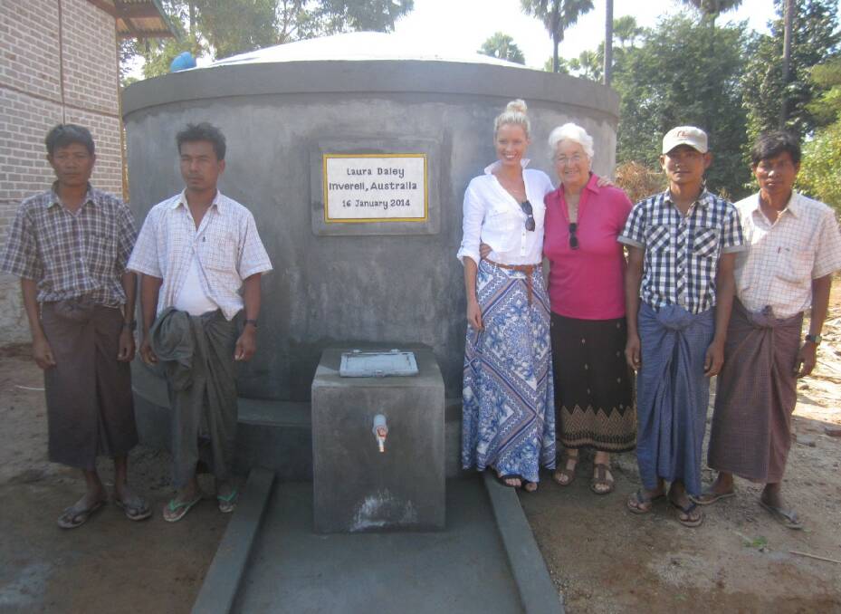 Laura Daley and Rosemary Breen stand with the newly constructed tank created by the men around them.